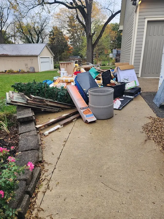 Dumpster being loaded with debris for Estate Cleanout Dumpster Rental in Flowood